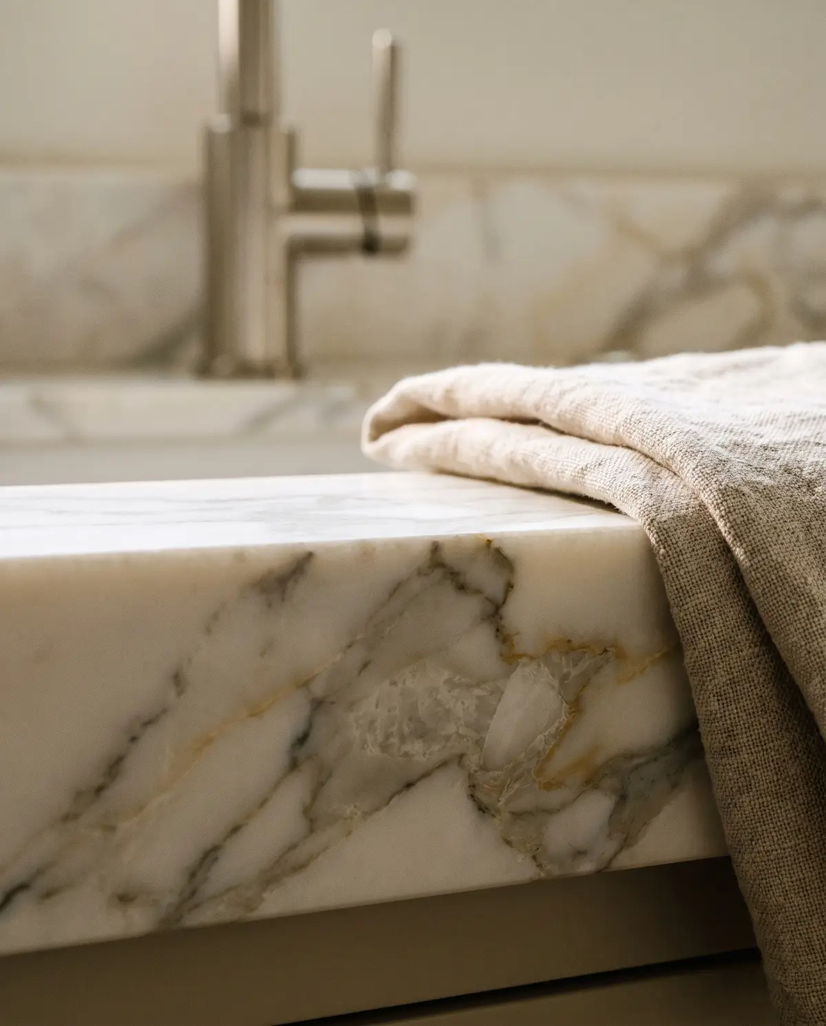 Honed Calacatta marble counter edge with a folded linen cloth